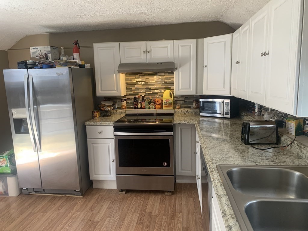 34 Grove Street Lynn, MA 01905 - Photo 13 of 37 a kitchen with stainless steel appliances granite countertop a refrigerator stove and sink