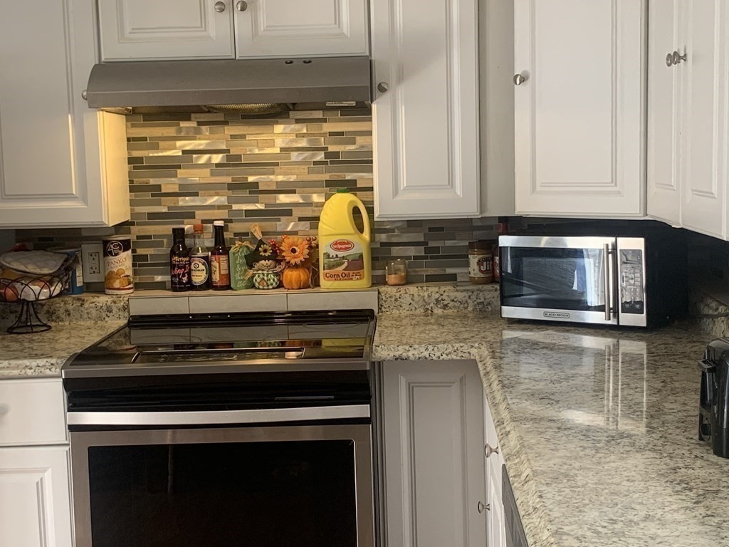 34 Grove Street Lynn, MA 01905 - Photo 14 of 37 a kitchen with granite countertop a stove and a microwave