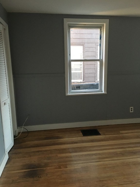 34 Grove Street Lynn, MA 01905 - Photo 19 of 37 an empty room with wooden floor and windows