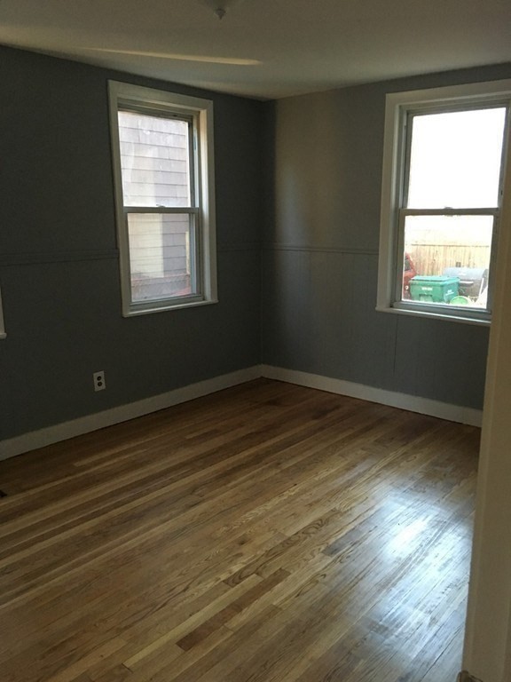 34 Grove Street Lynn, MA 01905 - Photo 21 of 37 a view of an empty room with wooden floor and a window