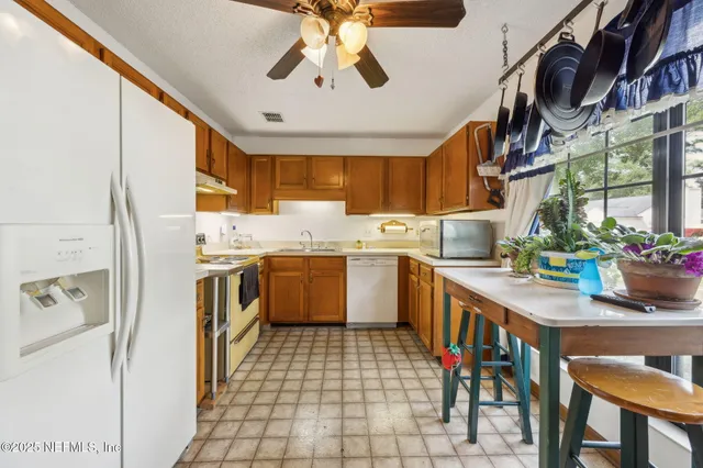 a kitchen with a sink appliances cabinets and furniture