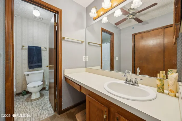 a bathroom with a sink toilet a mirror and shower