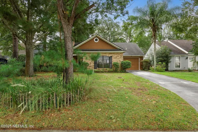 a front view of a house with yard and green space