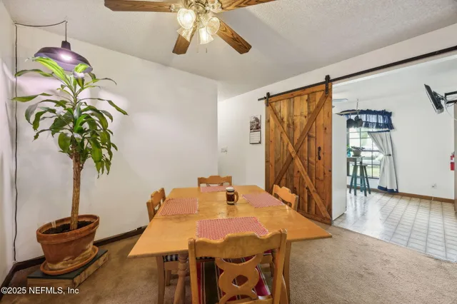 a view of a dining room with furniture and a chandelier
