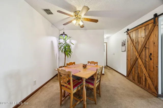 a view of a dining room with furniture and a potted plant