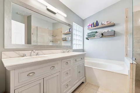 a bathroom with a tub sink and a mirror