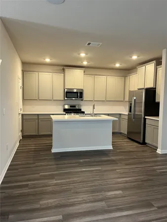 a large kitchen with stainless steel appliances granite countertop a stove a sink and a refrigerator