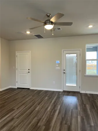 an empty room with wooden floor and windows