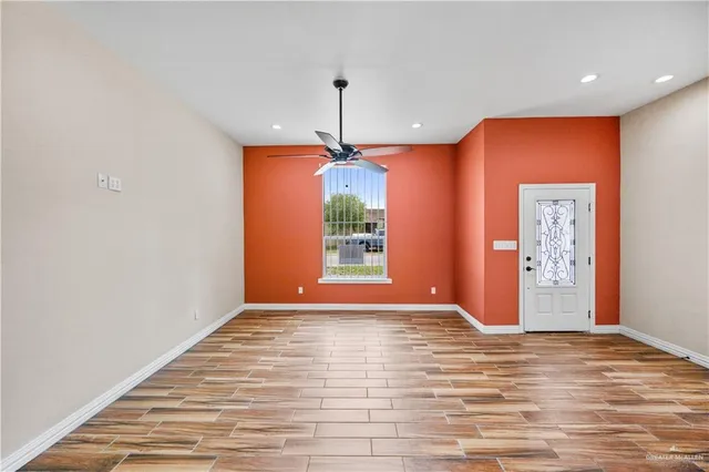 a view of empty room with window and wooden floor