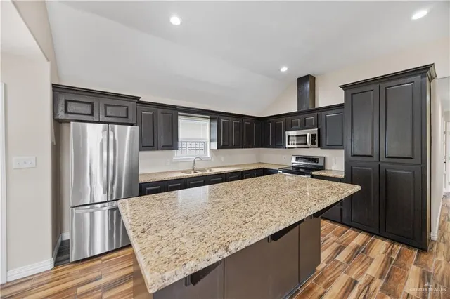 a kitchen with stainless steel appliances granite countertop a refrigerator and a sink