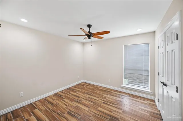 a view of a room with wooden floor and a ceiling fan