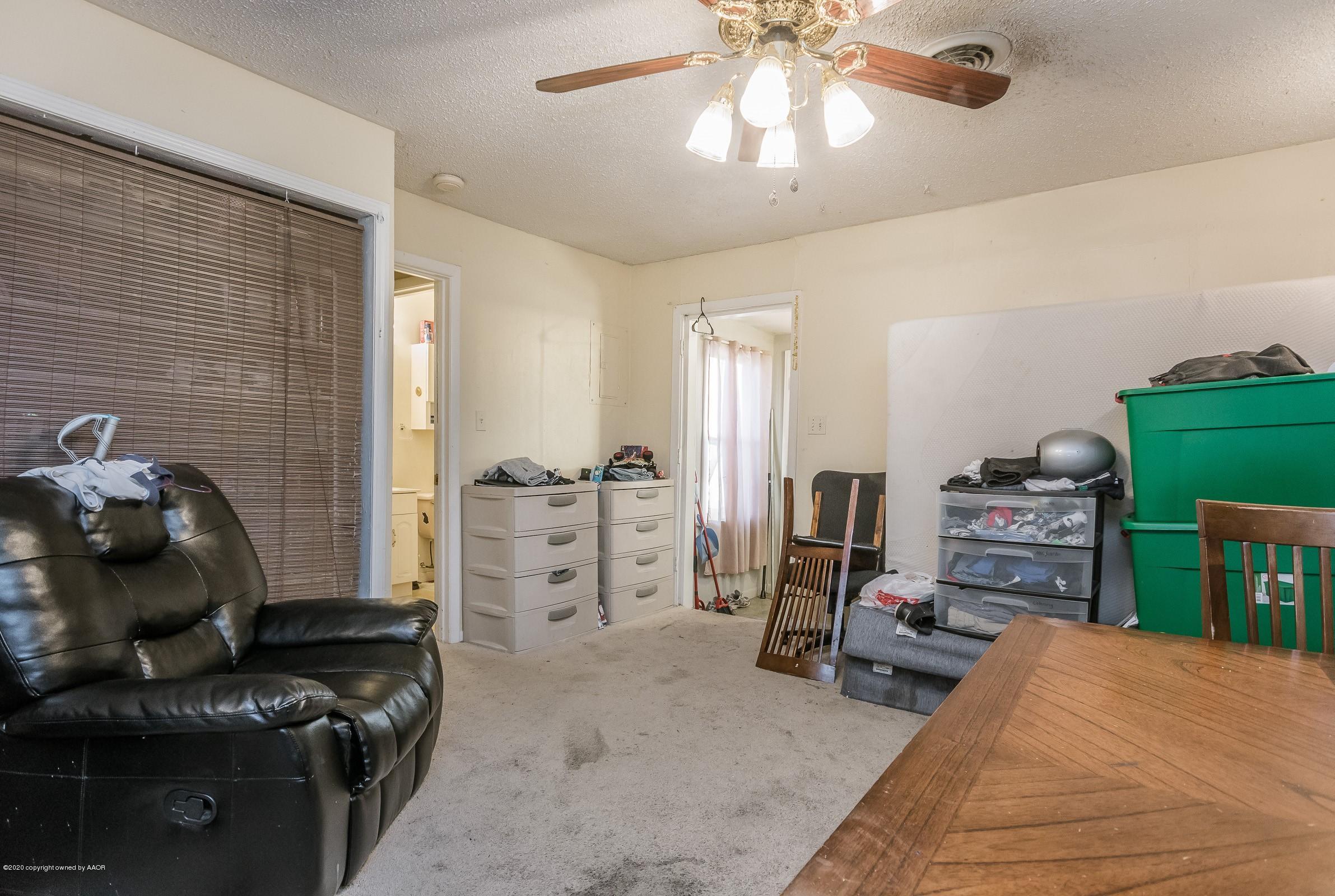 4602 South Travis Street Amarillo, TX 79110 - Photo 6 of 14 a bedroom with furniture and a chandelier