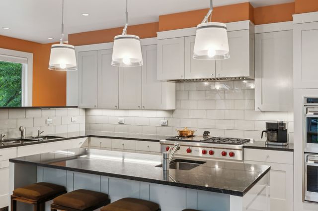 a kitchen with stainless steel appliances granite countertop a stove and a sink