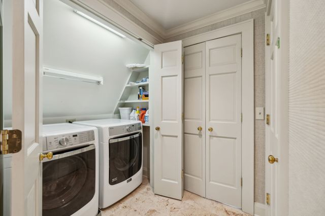 a view of a house with potted plants and a table and chair