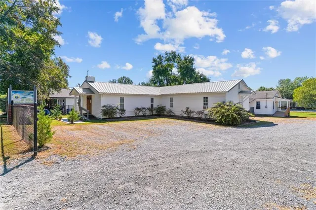 a view of a house with backyard and a tree