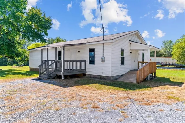 a kitchen with stainless steel appliances granite countertop a refrigerator a stove top oven a sink dishwasher and white cabinets with wooden floor