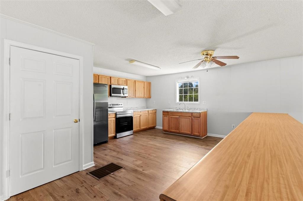 210 Hood Street Calhoun, GA 30701 - Photo 29 of 59 a kitchen with stainless steel appliances kitchen island a refrigerator sink and cabinets
