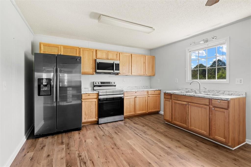 210 Hood Street Calhoun, GA 30701 - Photo 30 of 59 a kitchen with stainless steel appliances a refrigerator sink and microwave