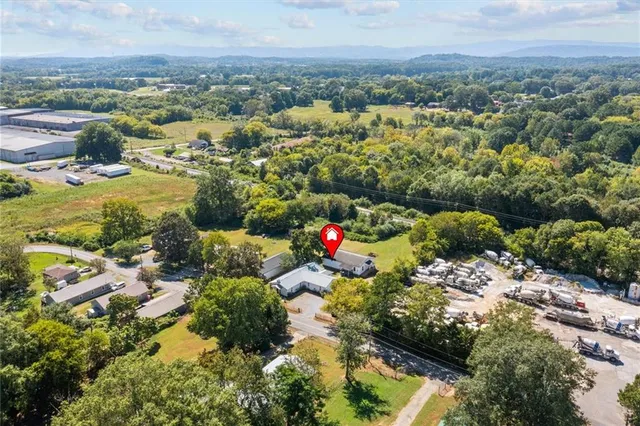 an aerial view of residential houses with outdoor space and trees