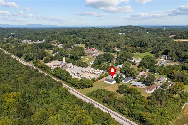 an aerial view of residential houses with outdoor space and trees