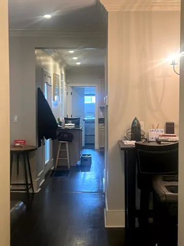 a living room with table chairs and a wooden floor