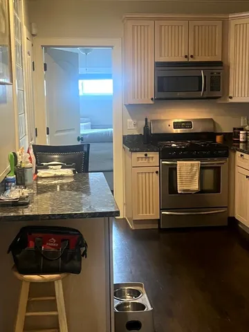 a kitchen with granite countertop a stove and a microwave