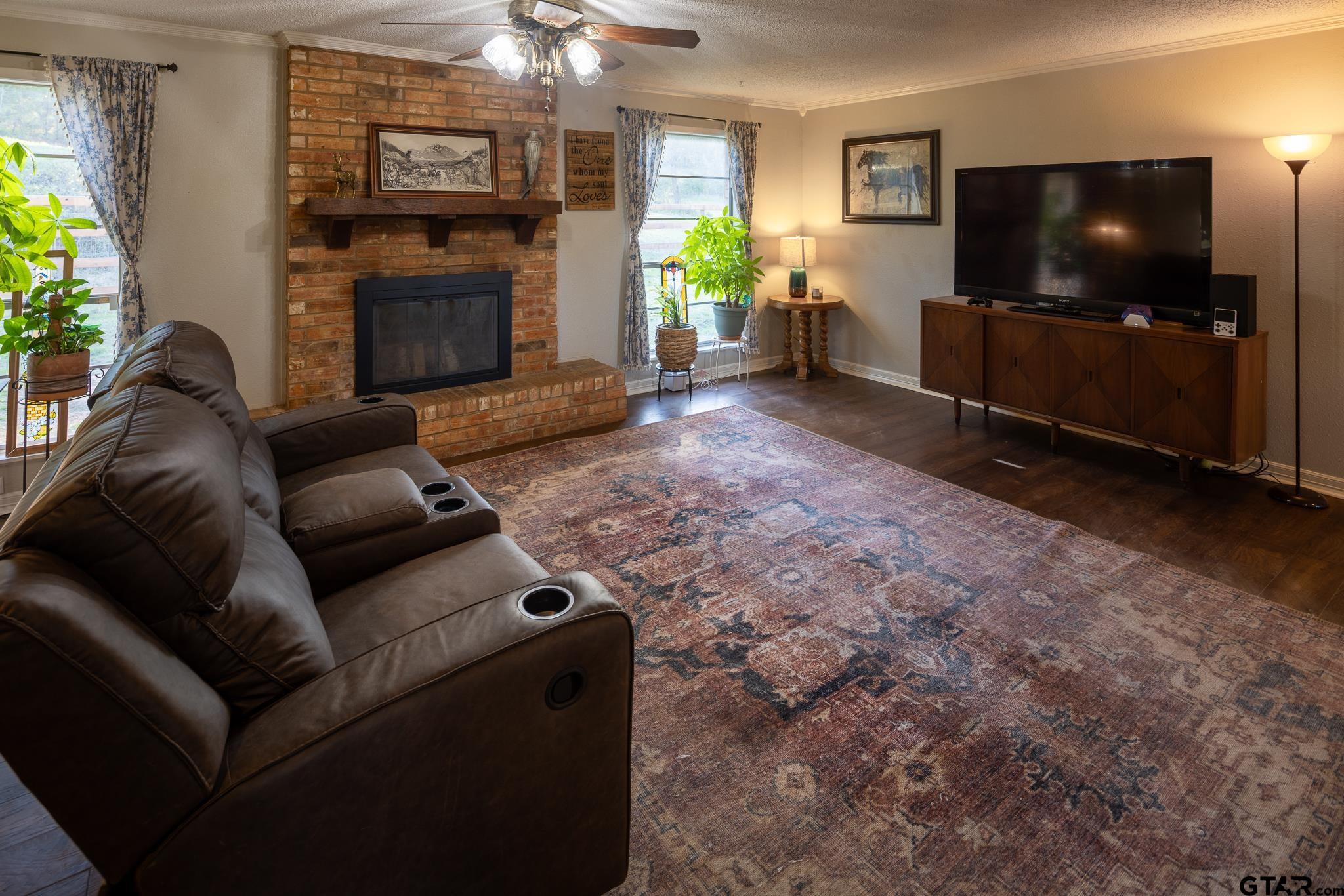 10733 County Road 4150 Tyler, TX 75704 - Photo 14 of 48 a living room with furniture a flat screen tv and a fireplace