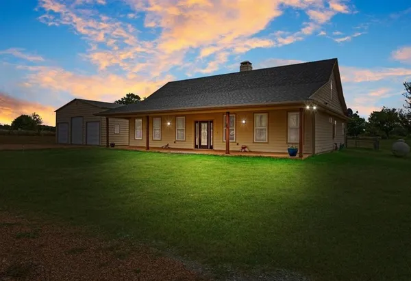 a view of a house with a big yard with wooden fence