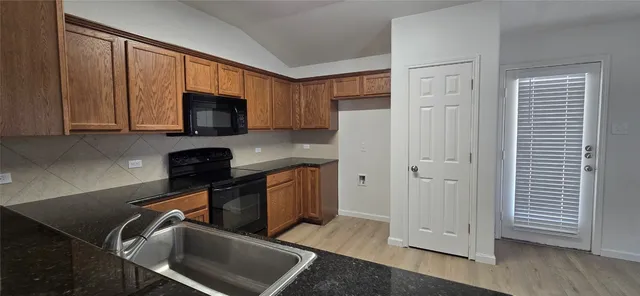 a kitchen with stainless steel appliances a stove a microwave a sink and cabinets
