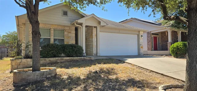 a view of a white house with a large tree