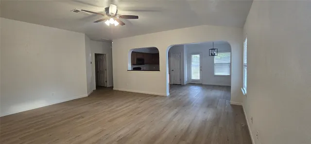 a view of a livingroom with wooden floor and a ceiling fan