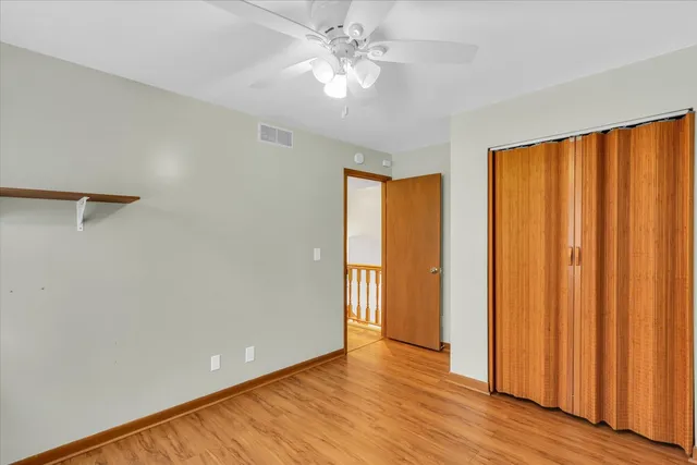 a view of an empty room with window and a ceiling fan