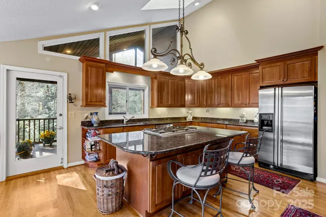 a kitchen with stainless steel appliances granite countertop a stove a refrigerator and a dining table