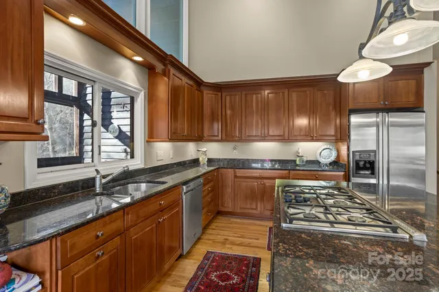 a kitchen with stainless steel appliances granite countertop a stove a sink and a microwave