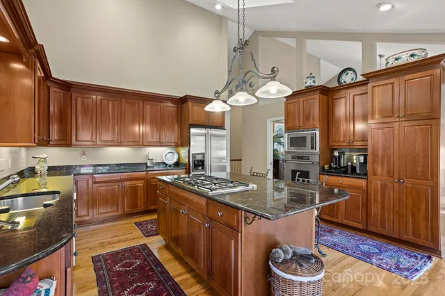 a kitchen with stainless steel appliances granite countertop a stove refrigerator and cabinets