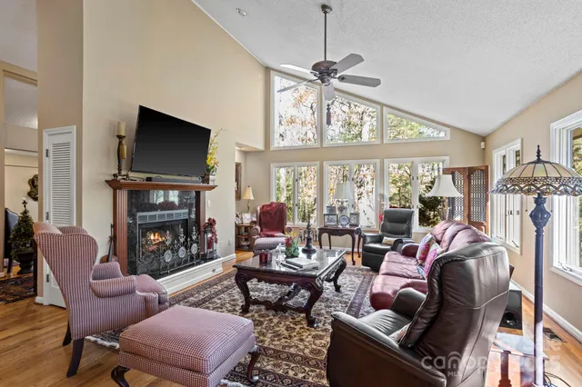 a living room with furniture a flat screen tv and a large window