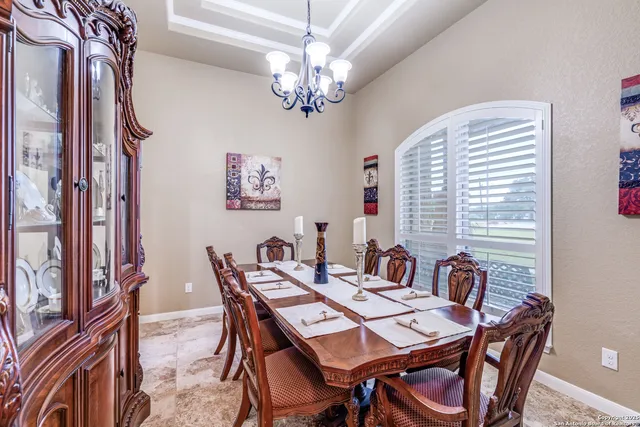 a view of a dining room with furniture a chandelier and wooden floor