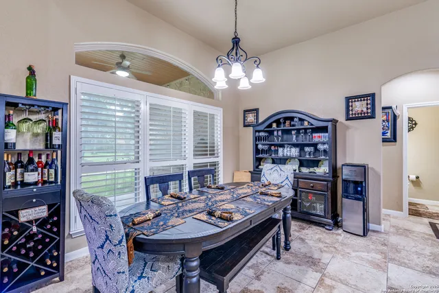a living room with furniture a chandelier and a bookshelf