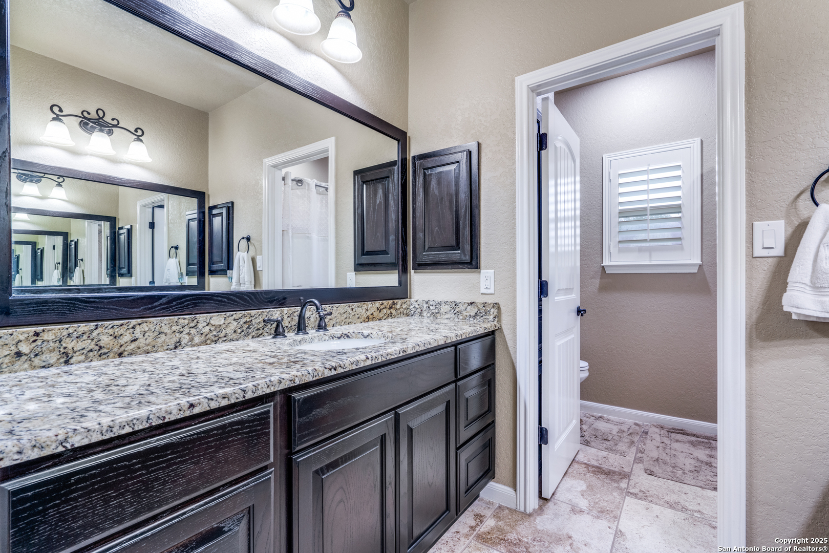 109 Bobcat Bend La Vernia, TX 78121 - Photo 18 of 36 a bathroom with a granite countertop sink and a mirror
