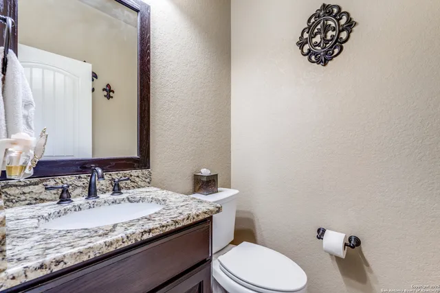 a bathroom with a granite countertop sink mirror and toilet