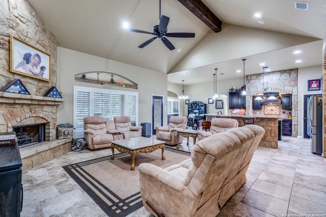 a living room with furniture a fireplace and a chandelier