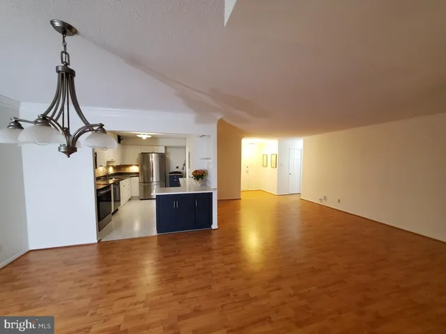 an empty room with windows and chandelier