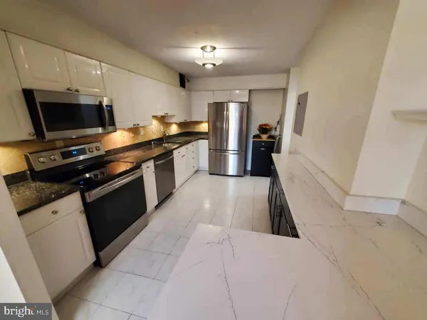 a kitchen with granite countertop white cabinets and black appliances