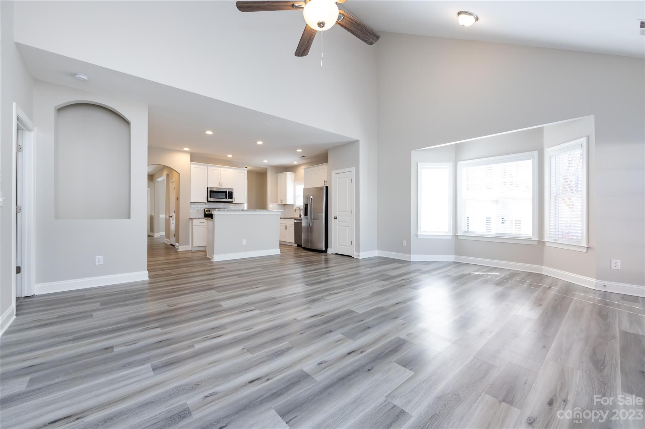 18909 Ruffner Drive Cornelius, NC 28031 - Photo 8 of 22 a view of an empty room with wooden floor and a kitchen