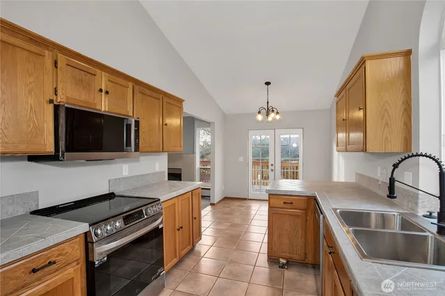 a kitchen with stainless steel appliances granite countertop a sink and a stove
