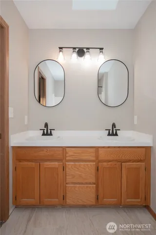 a bathroom with a double vanity sink and a mirror