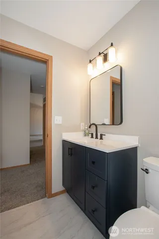 a bathroom with a toilet sink and mirror