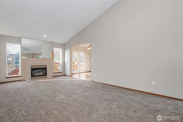 a view of an empty room with a fireplace and a window