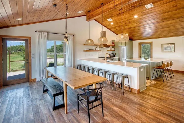 a open kitchen with dining table and wooden floors