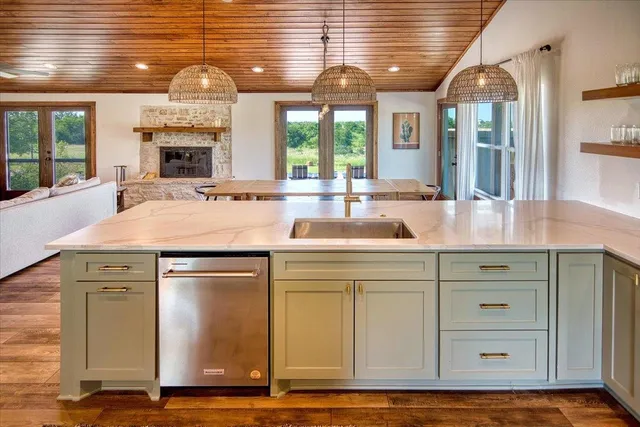 a kitchen with kitchen island granite countertop a stove and a sink